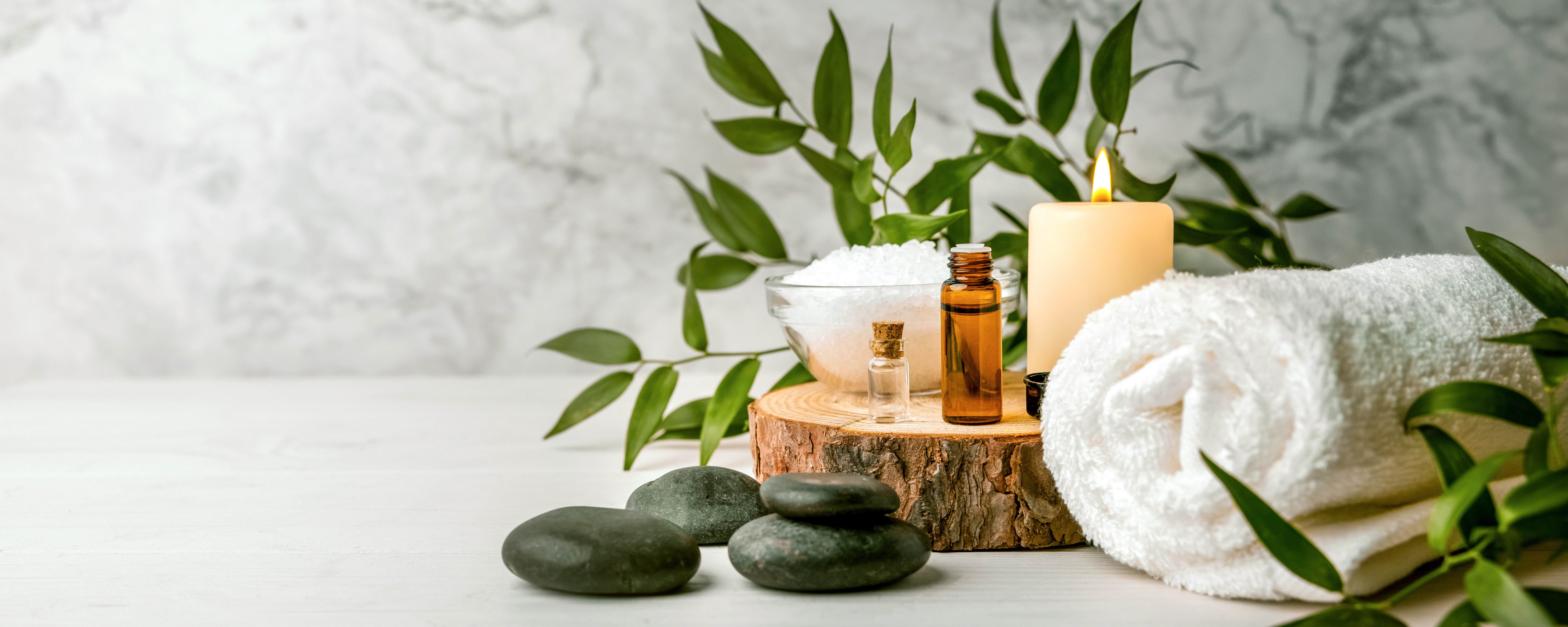 Candle, stones, towel on a wood slab
